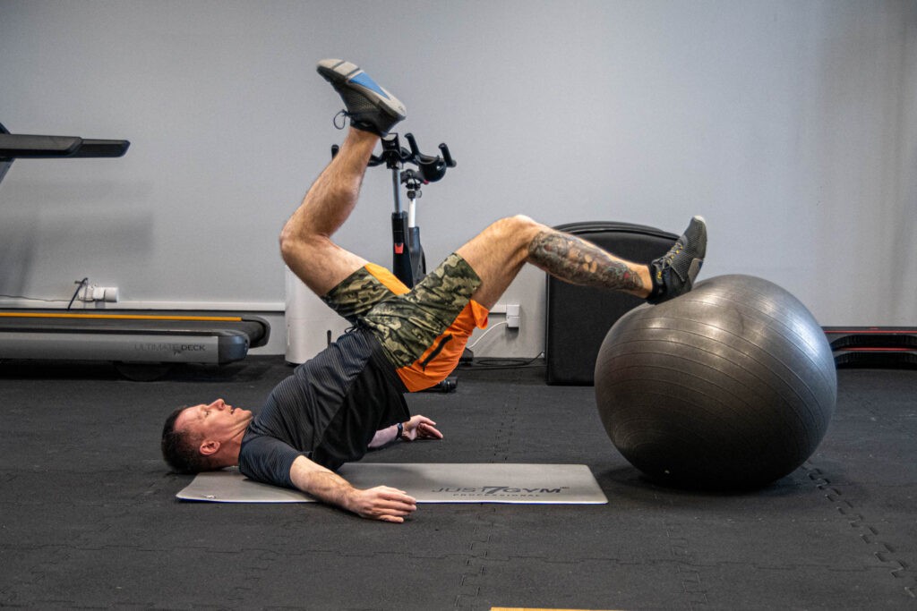 Leg Curl na piłce - progresja ćwiczeń na mięśnie dwugłowe 1 uginanie nóg na piłce jednonóż - 1 leg curl
