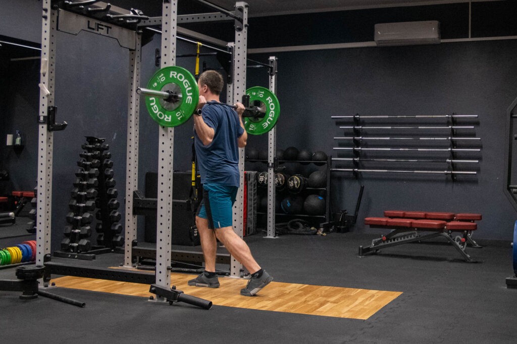 Split Squat ze sztangą: technika, dlaczego warto? 3 zabranie ze stojakow
