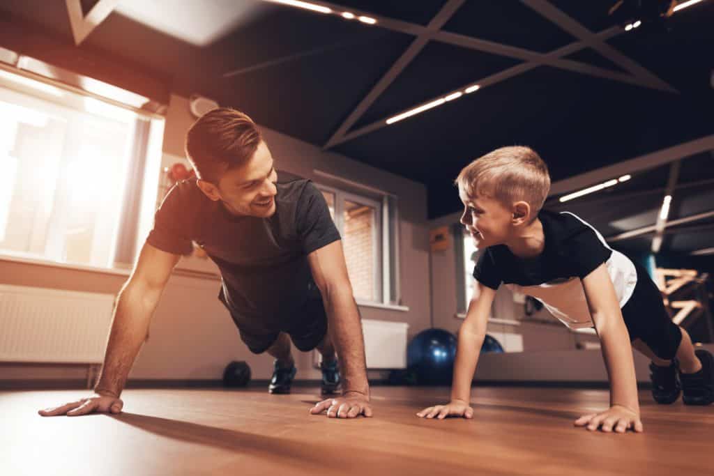 Czy trening siłowy może zatrzymać wzrost dziecka? 1 ojciec trenuje z synem na siłowni