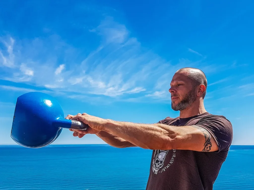 Mężczyzna wykonujący kettlebell swing na świeżym powietrzu