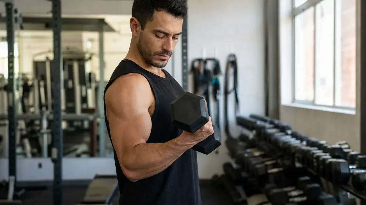 Trening bicepsa - uginanie hantla z supinacją, łokieć przy tułowiu